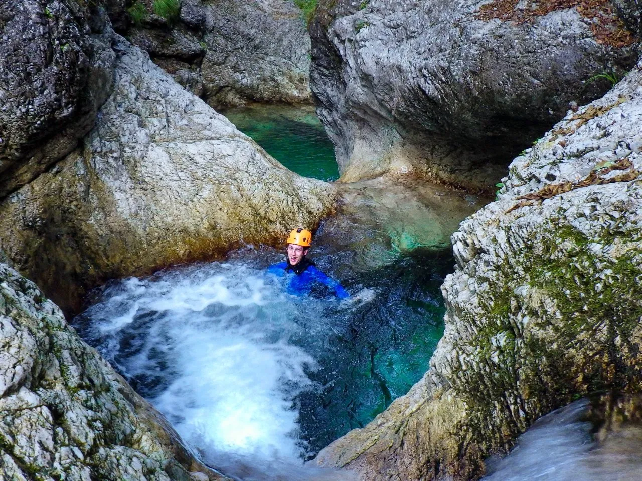 Swimming in bubbly stream on canyoning Slovenia